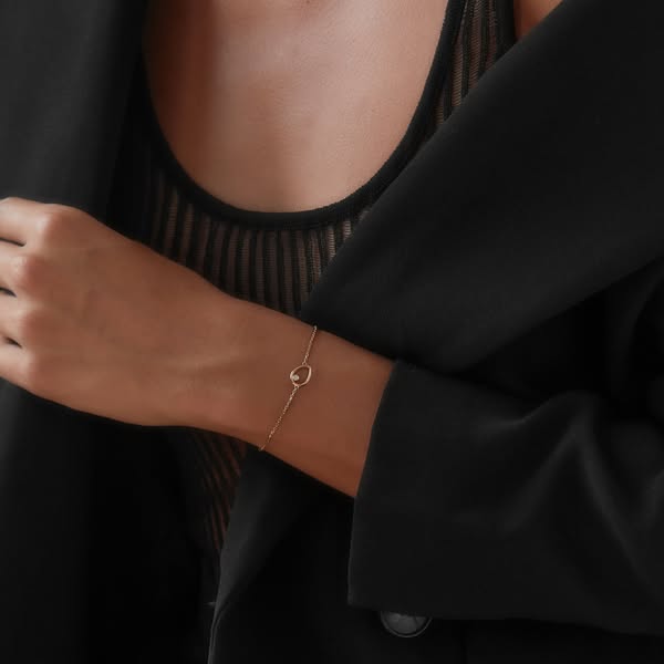 Gold Teardrop bracelet with an open teardrop charm worn on the wrist