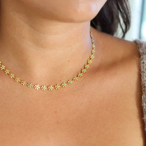 Gold flower necklace worn close-up on the neck